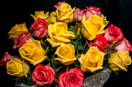 Large bouquet of yellow and red roses isolated on black backgroundの写真素材