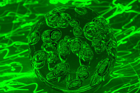 The abstract image of a glowing green sphere with ellipses and circles on a black background with...