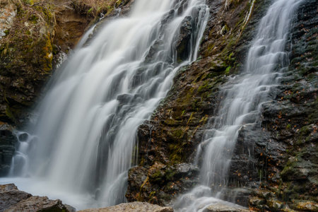 Beautiful view of the waterfall with smooth water falling among the rocks and stones, shot long...