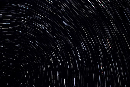 Abstract decorative space background with traces of stars in the form of tracks in the night skyの写真素材