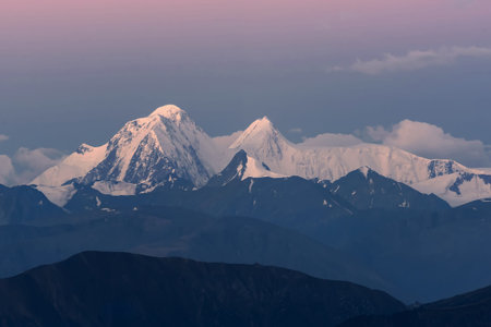 Scenic view of the beautiful mountain peaks with snow and glaciers, the contours of the mountains, and pink sky at sunriseの写真素材