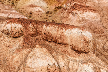 Colorful abstract background of textures of colored rocks with cracks, fractures and rare vegetationの写真素材