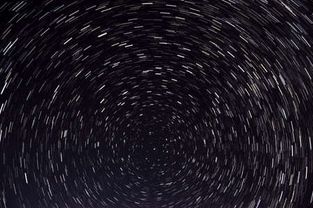 Abstract space background with traces of stars revolving around a polar star in the form of circular tracks against the background of black night skyの写真素材