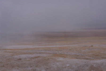 Amazing view with the first autumn snowfall in the steppe and a lonely car on a snow-covered road...