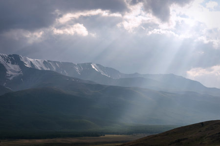 Amazing summer landscape with a lake, mountains covered with snow and forest, sun ray and light...