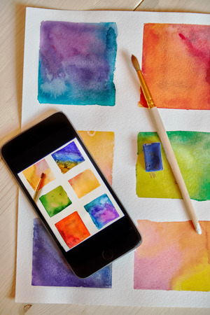 smartphone on arts hand drawn background with artist suppliesの写真素材