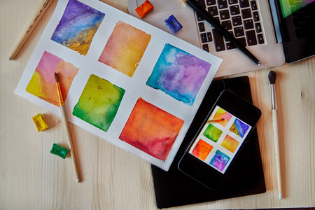 smartphone on arts hand drawn background with digital artist supplies: brushes, laptop, paperの写真素材