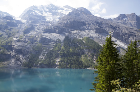 Amazing tourquise Oeschinnensee with waterfalls and Swiss Alps, Kandersteg, Berner Oberland, Switzerland.の写真素材