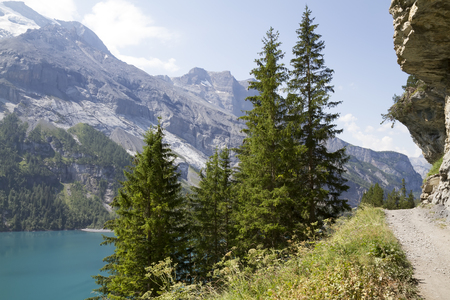 Amazing tourquise Oeschinnensee with waterfalls and Swiss Alps, Kandersteg, Berner Oberland, Switzerland.の写真素材