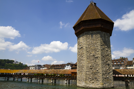 Urban view of the famous wooden bridge and tower on the river in the old town of Lucerne in Switzerlandの写真素材