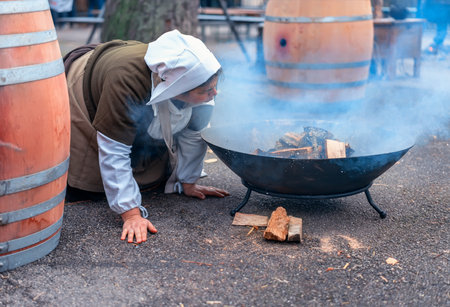 GENEVA, SWITZERLAND - DECEMBER 08, 2019: Escalade is an annual festival held in December in Geneva, Switzerland. The girl is fanning the fire.のeditorial素材