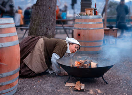 GENEVA, SWITZERLAND - DECEMBER 08, 2019: Escalade is an annual festival held in December in Geneva, Switzerland. The girl is fanning the fire.のeditorial素材