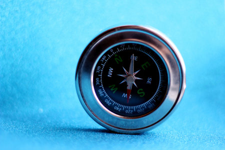 compass on an abstract blue background with bokeh.
