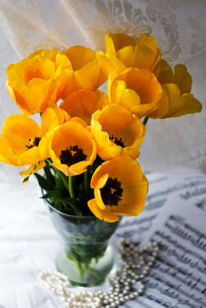 bouquet of huge yellow tulips in a vase on a white background.の写真素材