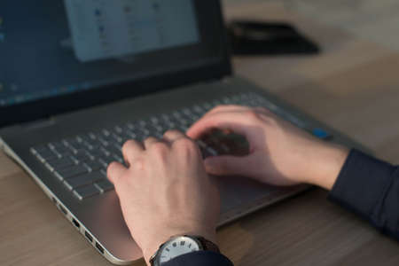 Hands typing on a laptop keyboard. Man working in the workplace.の写真素材