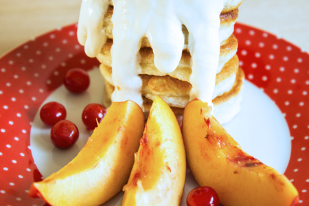Flour pancakes with sour cream and berries. Close-up. Selective focus.の写真素材