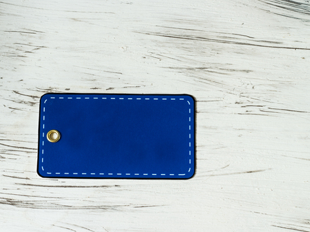 An empty blue price tag on the background of an old white board. Country style.の写真素材