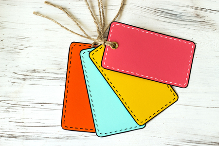 Multicolored empty tags against the old tree background. Country style. Selective focus.の写真素材