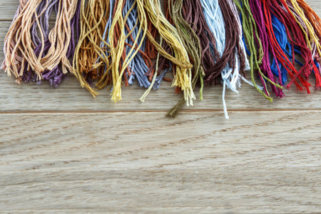 Threads for embroidery on a light wooden background. Background and texture.