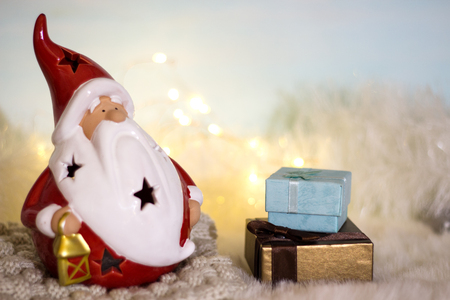 Christmas and New Year background. Santa Claus and boxes with Christmas gifts in candlelight. The concept of warm and cozy winter holidays.の写真素材