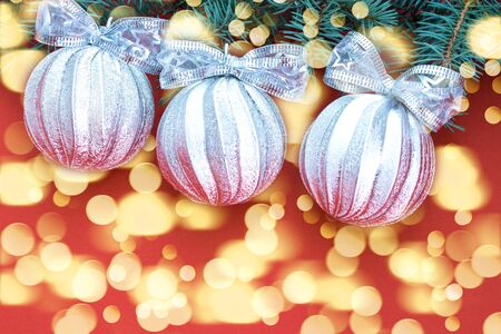 Christmas background. Silver balls and fir branches on a red background. Place for text.の写真素材