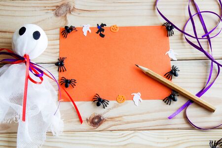 Halloween background. Halloween flatlay. Ghost, bat, pumpkin and spiders on a wooden background with place for text.の写真素材