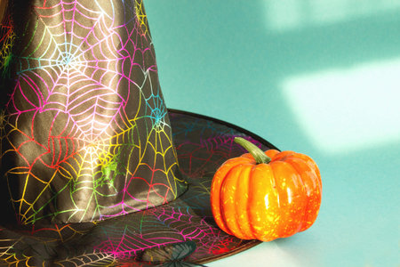 Magic hat and pumpkin on a light background. Halloween background. Traditional decoration for a...