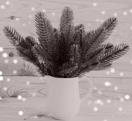 Christmas and New Year. The concept of Christmas decor from natural materials. Christmas tree branches in a white jug on a wooden background. Place for text.の写真素材