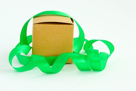 Craft box and green ribbon isolated on a white background. Holiday surprise. Gift wrapping. Happy Holidays Concept. Copy space.の写真素材