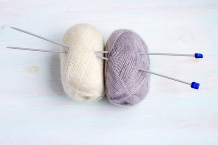 Threads for knitting natural tones on a light wooden background. Female hand-made hobby. Handicraft. Copy space.の写真素材