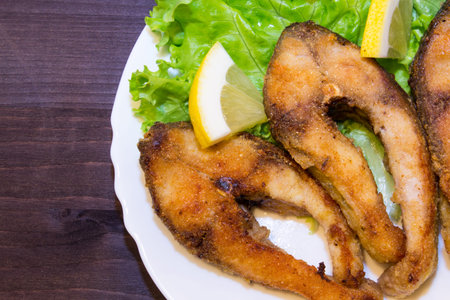 Step 3. Baked steak carp with lemon on lettuce. A traditional fish recipe. Close-up. Copy space. Top...
