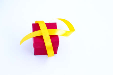 Red box with gold ribbon isolated on white background. The concept of wrapping gifts for the holiday. Top view.の写真素材