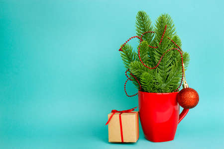 Christmas and New Year. Christmas composition with a red mug, branches of a Christmas tree and a gift box. Blank for a Christmas card. Copy space.の写真素材