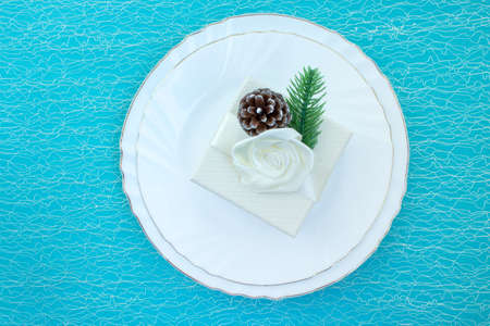 Elegant table setting for a Christmas dinner. Plates and gift box on a light blue background. Christmas and New Year.の写真素材