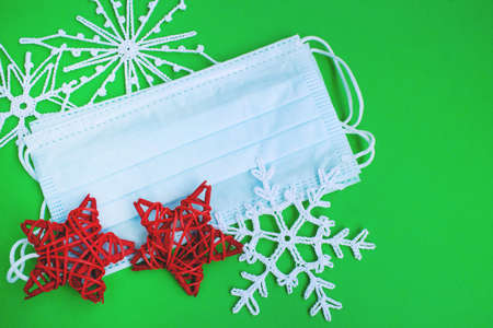 Winter holidays with coronavirus. Face mask and Christmas decorations. Concept for celebrating Christmas and New Year during a pandemic.の写真素材
