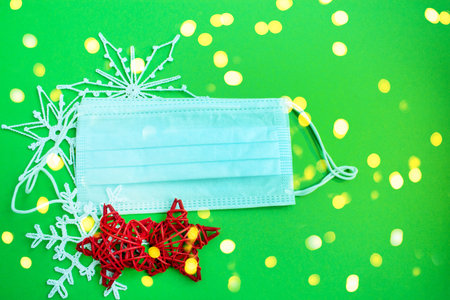 Festive winter background.Face mask and Christmas decorations. Concept for celebrating Christmas and...