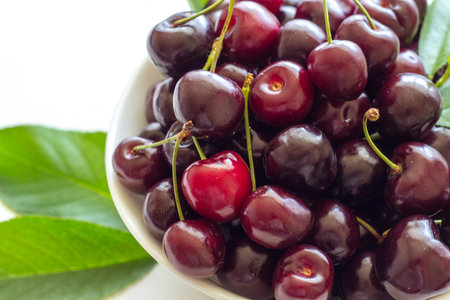 Cherry berries in a bowl on a white background. Fresh cherries. The concept of a healthy diet and support for local producers. Close-up. Top view.の写真素材