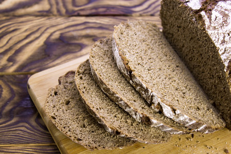 Traditional rye bread. Sliced â€‹â€‹rye bread on a cutting board. Bread slices. Close-up....