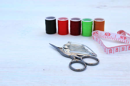 Needlework. Threads, scissors, tape measure, pins. Materials for creative work. Female hobby concept. Copy space.の写真素材
