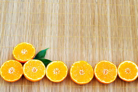 Summer background with orange slices. Orange slices on a light wooden background. Juicy and colorful summer background. Citrus slices. Copy space.の写真素材