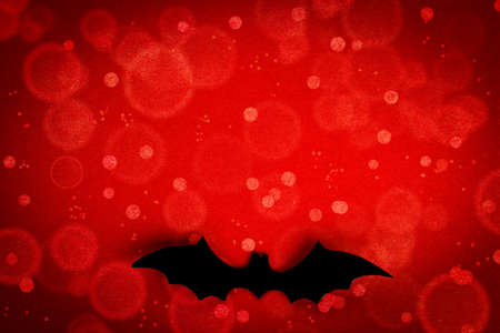 Halloween background. Bat on a red background. Halloween design concept. Mockup for invitation and greeting card. Flatlay. Copy space.の写真素材