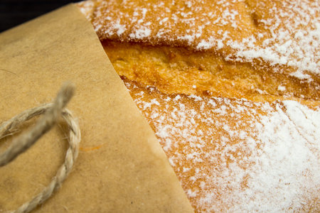 Baguette. Fresh golden baguette on an old wooden table. French baguette crust close-up. Traditional...