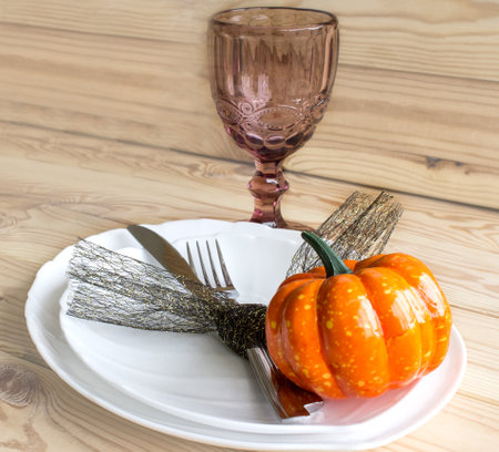 Festive table setting in the style of Halloween. Fork, knife, plates, glasses and autumn decor. Place for text.の写真素材
