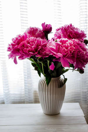 Peonies. A bouquet of peonies on a light background.Peonies in a vase. Spring flowers. Bouquet in the interior.の写真素材