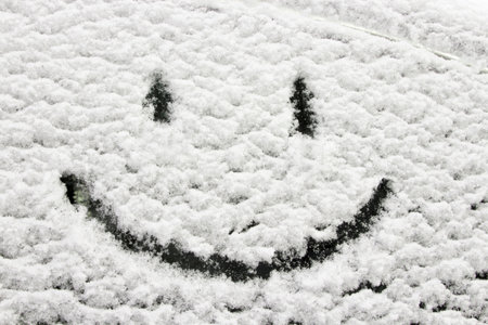 winter decoration. Smiley face on a snowy car window. Hearty congratulations on the winter holidays. Creating a good mood. background.の写真素材