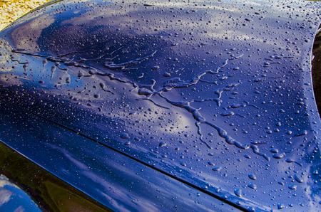 Raindrops or water droplets on the surface of the car. Water flows from the hood of the car. Hydrophobic properties after the application of nanoceramics. Abstract background and water texture for design.の写真素材