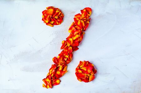 Symbol of percent from rose petals. Percent symbol, made from yellow-red petals rose isolated on a white background.の写真素材