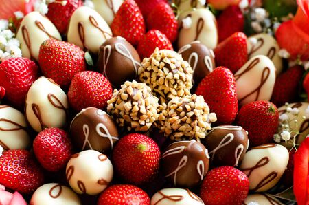 Composition of red-yellow pink flowers, fresh strawberries and fresh strawberries in chocolate.の写真素材