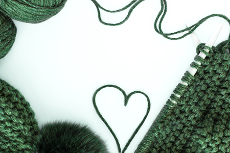 knitting, needlework, yarn, scarf and hat with a pompon green on a white background, space for text, free spaceの写真素材