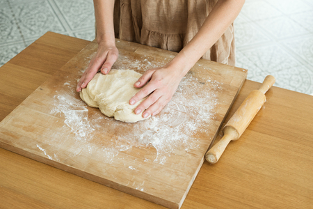 yeast dough lying on a wooden cutting board sprinkled with flourの写真素材